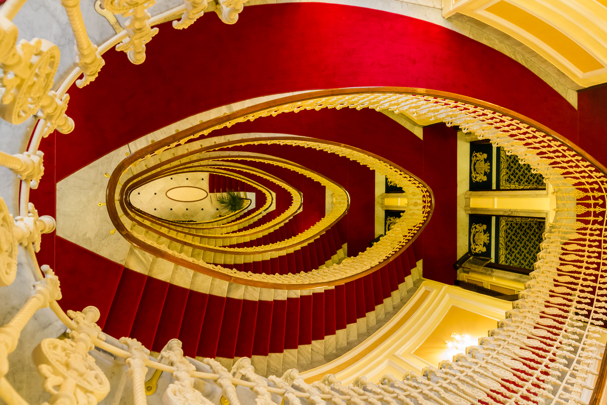 Ovale Prunktreppe mit rotem Läufer im Palazzo (Hotel Bristol)