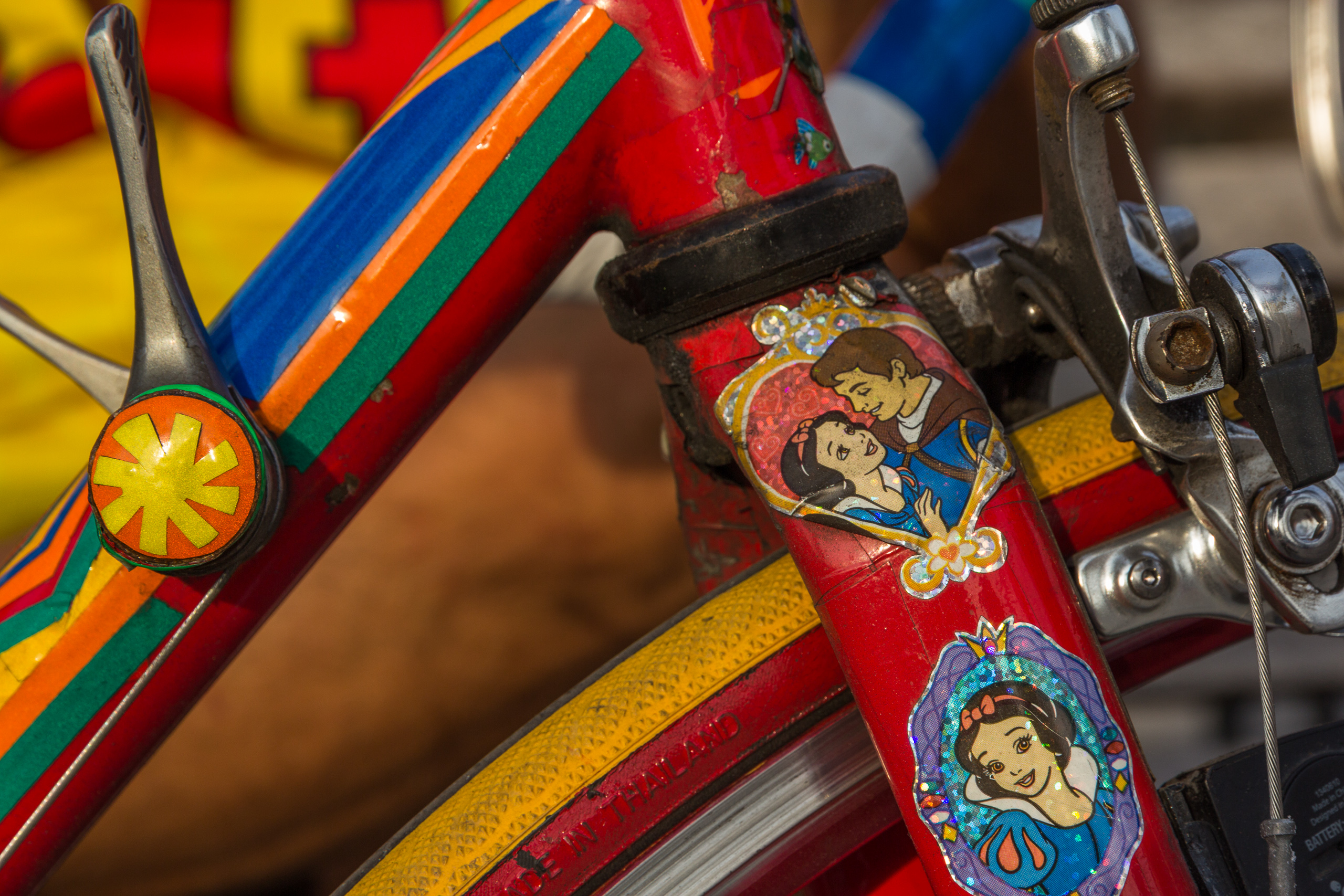 Buntes Kinderrad mit Disney-Aufklebern am Straßenrand