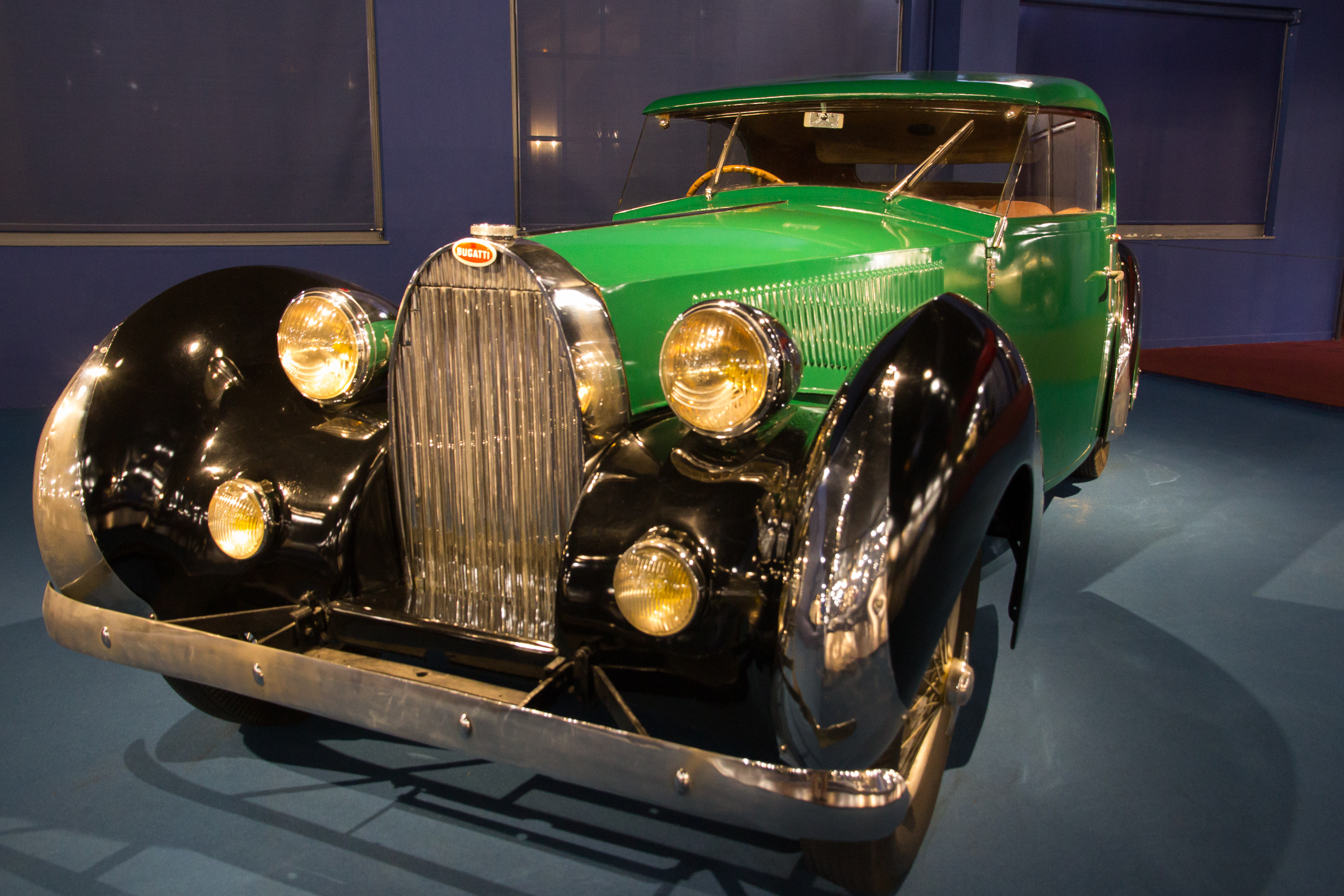 Grüner Bugatti mit schwarzen Kotflügeln und vier gelben Scheinwerfern