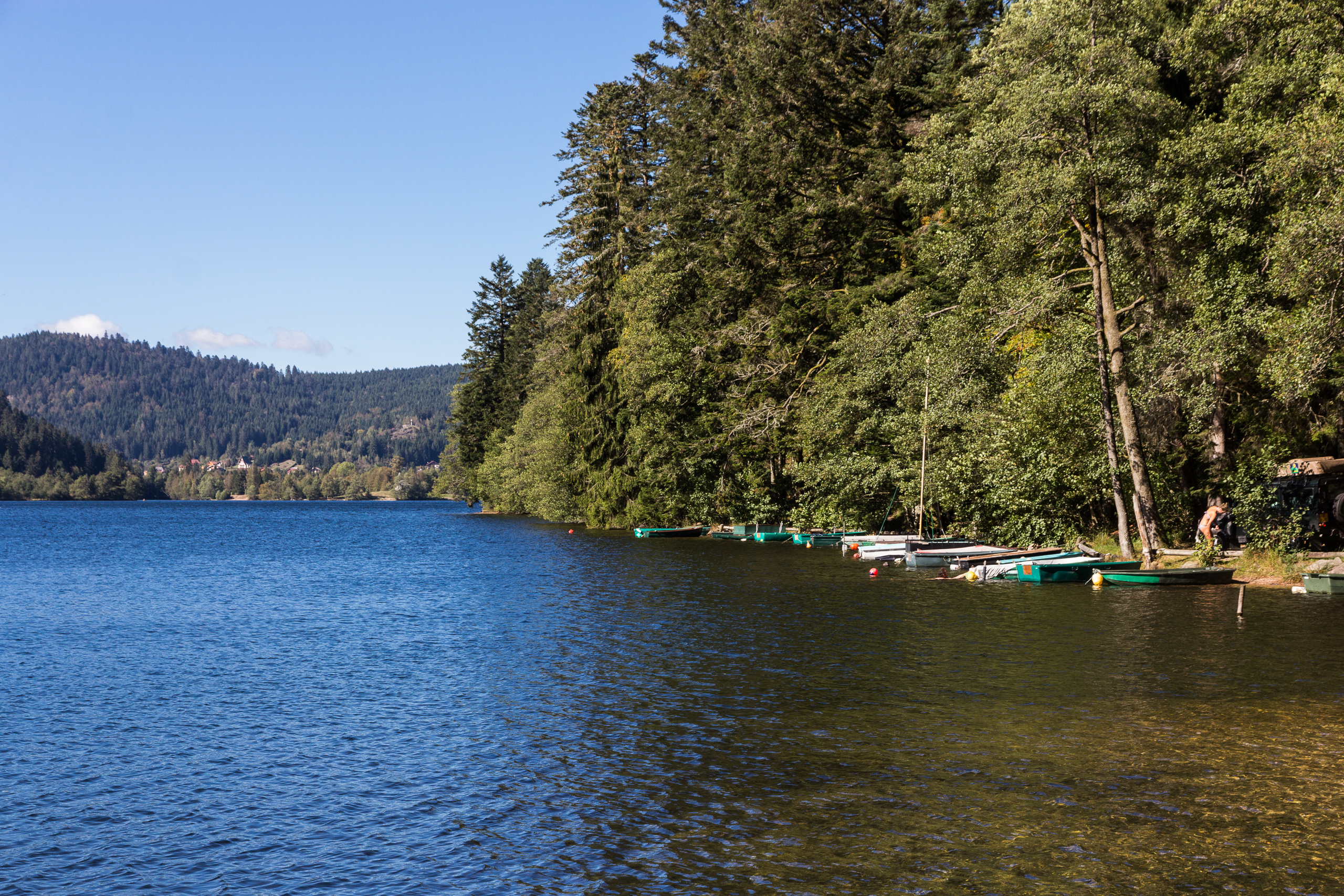 Lac de Longemer mit vertäuten Ruderbooten am bewaldeten Ufer